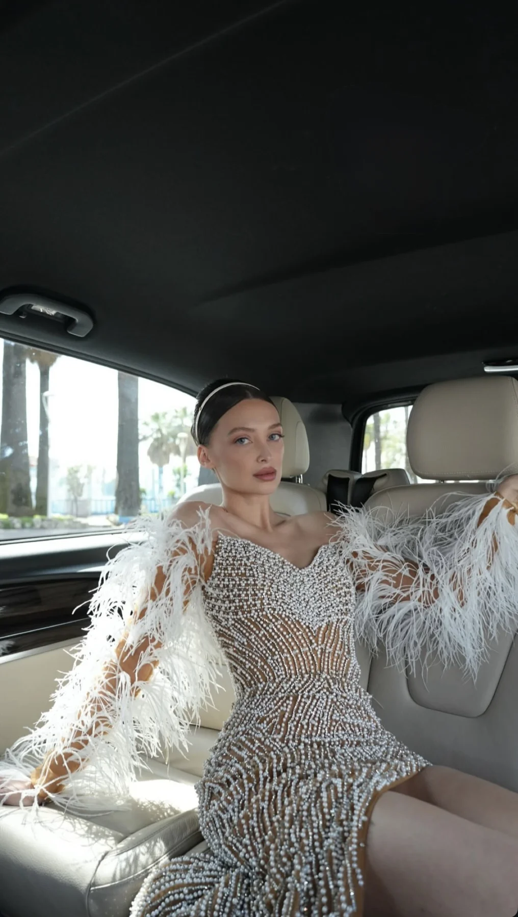 An event hairstyle with a feathered silver outfit